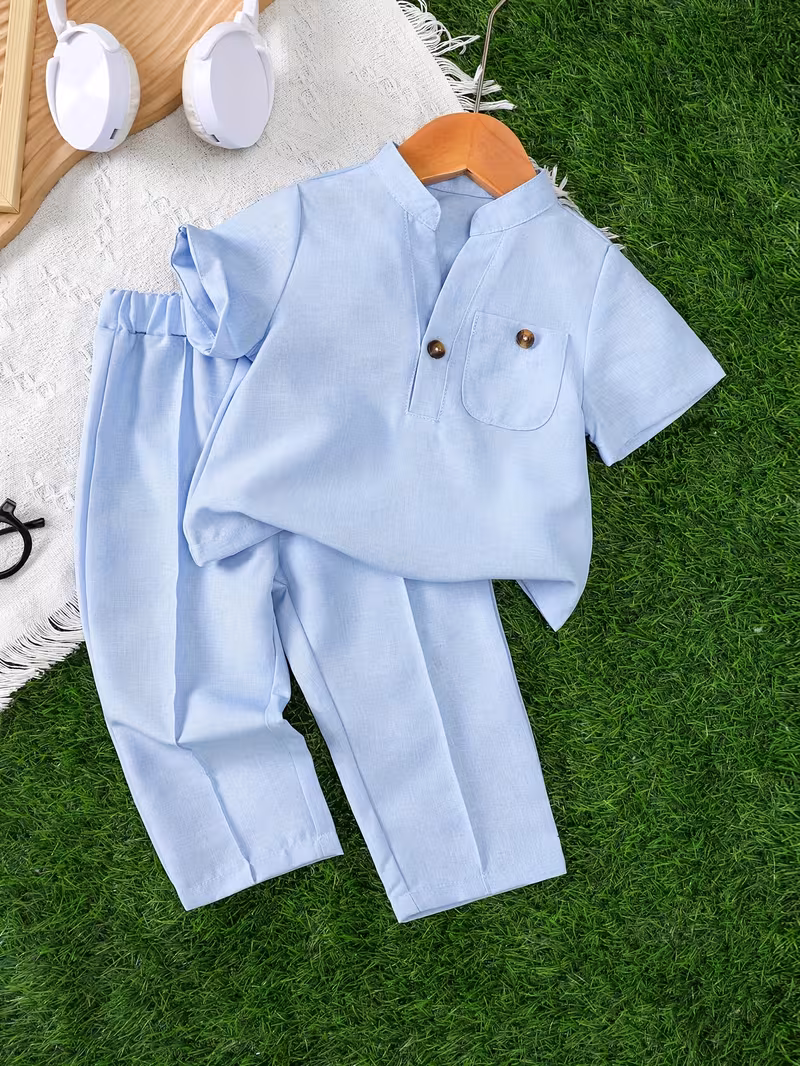 Ensemble deux pièces pour bébé garçon comprenant un haut à manches courtes avec un col rond vertical et une poche décorative en forme de V semi-ouverte, associé à un pantalon long de couleur unie. L'ensemble comprend des boutons et convient aux tenues d'extérieur pendant l'été.
